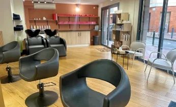 L’intérieur du salon avec son parquet et ses fauteuils noirs